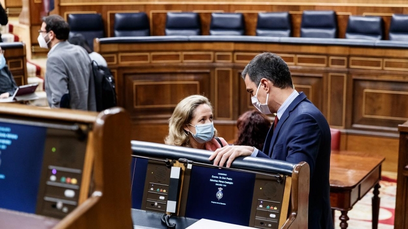 El presidente del Gobierno, Pedro Sánchez, charla con su vicepresidenta económica, Nadia Calviño, en el Congreso.