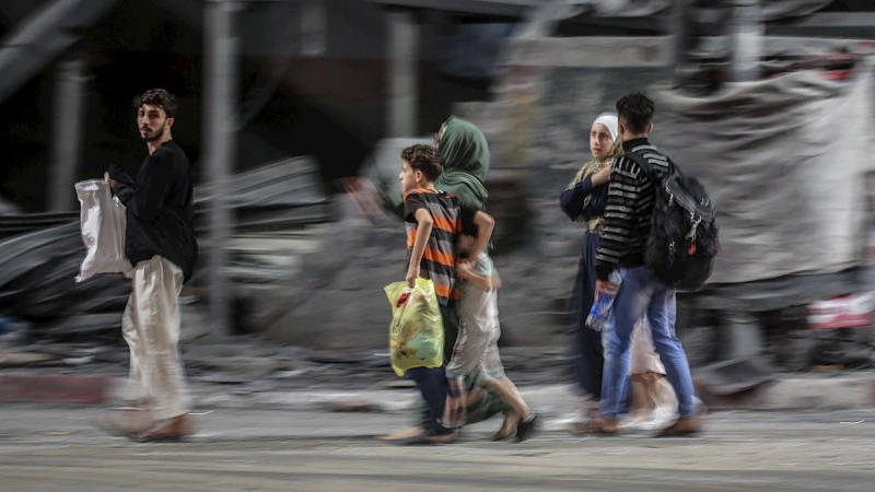 Una familia palestina huye de su casa en el barrio de Al Shejaeiya durante los ataques aéreos israelíes en el este de la ciudad de Gaza