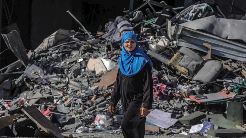 Una mujer palestina camina junto a una casa destruida tras un ataque israelí en la ciudad de Gaza, el 13 de mayo de 2021