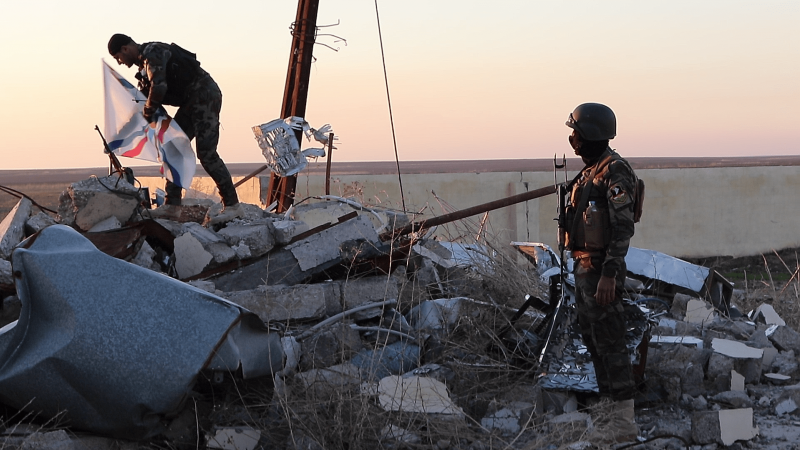 Milicianos asirios plantan la bandera de Mesopotamia sobre las ruinas de una casa destruida por el Daesh en Teleskoff.