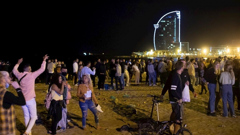 15/05/2021. Varios jóvenes recogen sus pertenencias en la playa de la Barceloneta mientras la Policía desaloja la zona, este sábado en Barcelona. - EFE