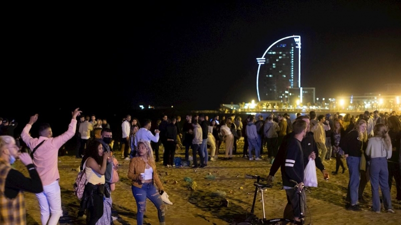 15/05/2021. Varios jóvenes recogen sus pertenencias en la playa de la Barceloneta mientras la Policía desaloja la zona, este sábado en Barcelona. - EFE