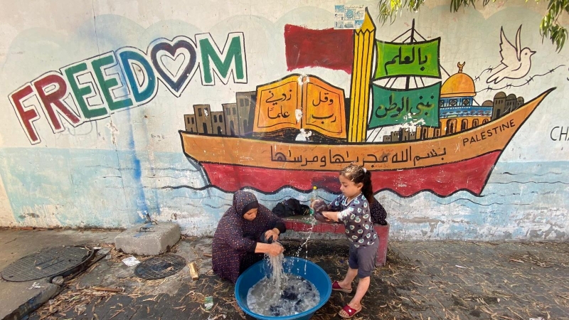 Los palestinos, que huyeron de sus hogares debido a los ataques aéreos y de artillería israelíes, lavan su ropa en una escuela dirigida por las Naciones Unidas donde se refugian, en la ciudad de Gaza