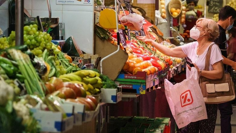 Una mujer compra fruta en un mercado de Zaragoza.