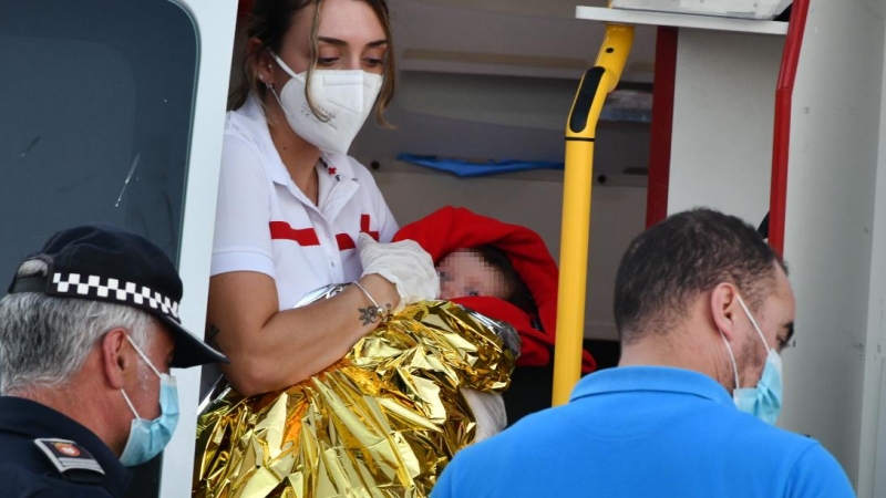 Cruz Roja atiende a un bebé en la playa del Tarajal, a 17 de mayo de 2021, en Ceuta (España).