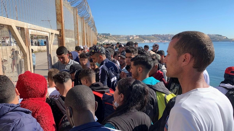 Un grupo de personas tratan de cruzar la valla fronteriza que separa Fnideq (Castillejos, Marruecos) y Ceuta este miércoles 19 de mayo de 2021.