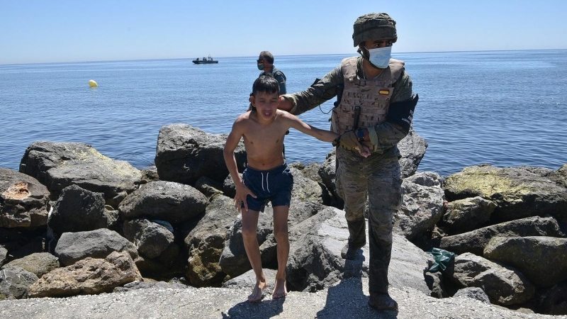 Un militar del ejército español ayuda a un menor migrante procedente de Marruecos a su llegada a Ceuta, a 19 de mayo de 2021, en Ceuta, (España).