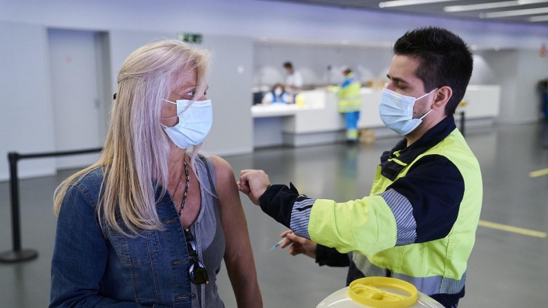 Un sanitario vacuna a una mujer con la dosis de Pfizer, en el Wanda Metropolitano, a 19 de mayo de 2021, en Madrid