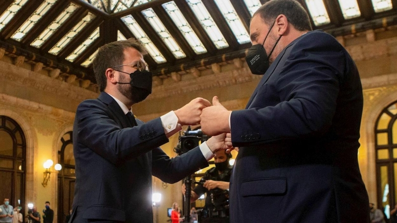 El nuevo presidente de la Generalitat, Pere Aragonès (i) es felicitado por del presidente de ERC, Oriol Junqueras (d) tras ser elegido por mayoría absoluta en la segunda jornada del debate de investidura celebrado en el Parlament este viernes.