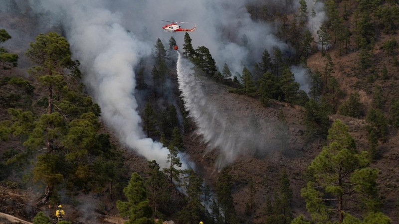 22/05/2021. Un helicóptero del Gobierno de Canarias descarga agua sobre una de las zonas afectadas por el incendio en el municipio de Arico (Tenerife). - EFE