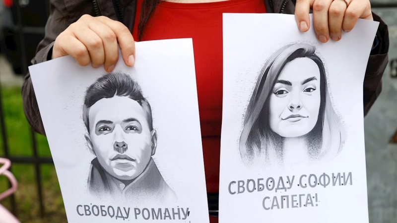 Una manifestante sujeta dos retratos de Román Protasevich y su pareja, Sofia Sapega, durante una protesta en Riga, Letonia, contra la detención de ambos.