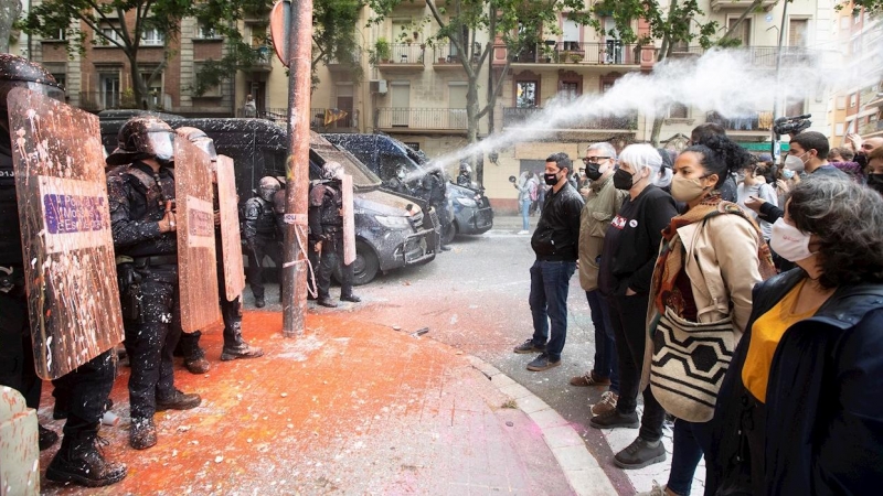 Policías antidisturbios de los Mossos d'Esquadra frente a las personas conventradas para evitar el desalojo del edificio conocido como Bloc Llavors, en el barrio del Poble Sec de Barcelona, que han lanzando objetos y pintura contra la línea policial. EFE/