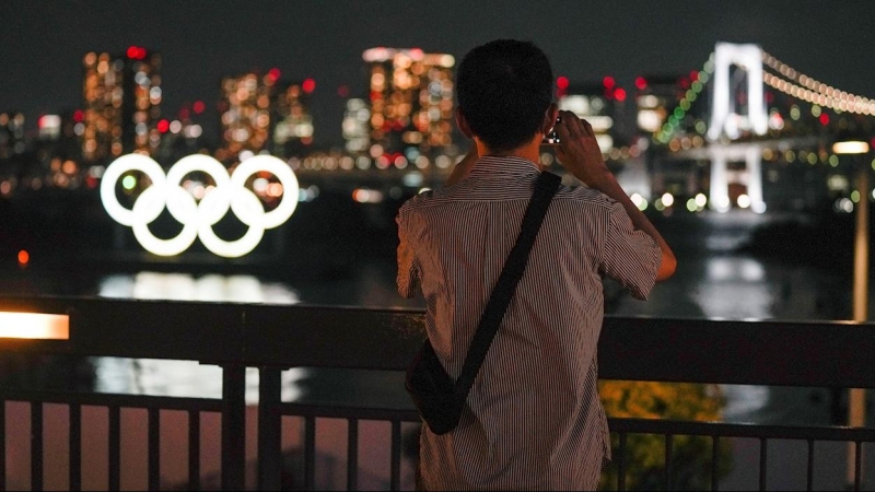 Una mujer toma una fotografía a los anillos de los Juegos Olímpicos en Tokio.