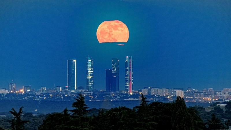 Superluna roja sobre las Torres Espacio, en Madrid, vista este miércoles desde la localidad de la sierra madrileña de Torrelodones.