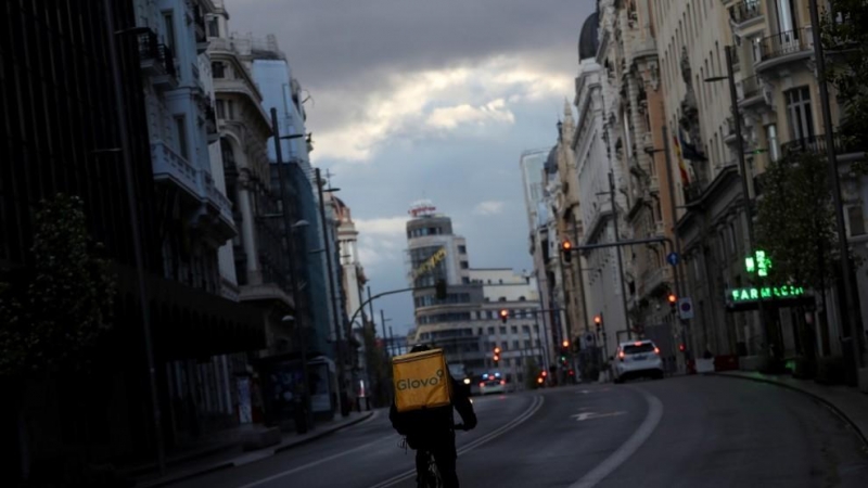 Un repartidor circula en bicicleta por la Gran Vía de Madrid, que permanece prácticamente sin coches debido a la crisis del coronavirus. Reuters/Susana Vera