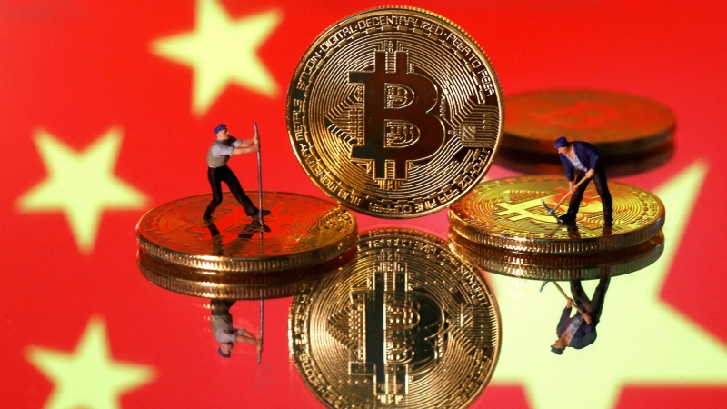 Ilustración de pequeñas figuras de juguete y representaciones de la moneda virtual bitcoin frente a una imagen de la bandera de China. - REUTERS