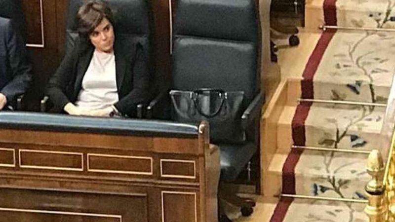 La exvicepresidenta Soraya Saénz de Santamaría sitúa su bolso en el escaño de Mariano Rajoy.