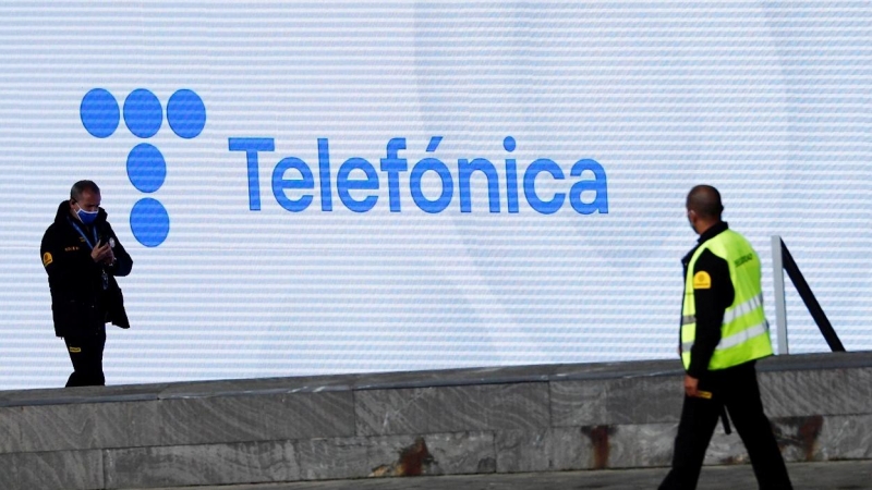 Dos guardias de seguridad, delante de una pantalla con el nuevo logo de Telefónica en su sede en la zona norte de Madrid. REUTERS/Sergio Perez