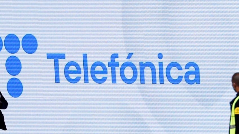 Dos guardias de seguridad, delante de una pantalla con el nuevo logo de Telefónica en su sede en la zona norte de Madrid. REUTERS/Sergio Perez