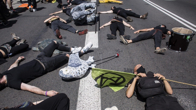 04/06/2021. Varias personas yacen en el suelo como parte de una acción posterior a la entrega del Manifiesto por la criminalización del Ecocidio, este viernes en Madrid. - EUROPA PRESS