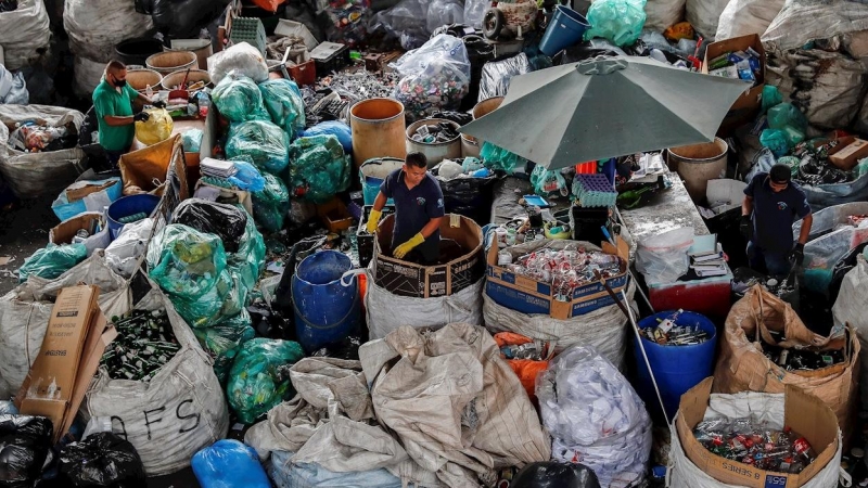 Trabajadores mientras organizan material en la cooperativa de reciclaje en el centro de la ciudad de Sao Paulo. - SEBASTIÃO MOREIRA / EFE