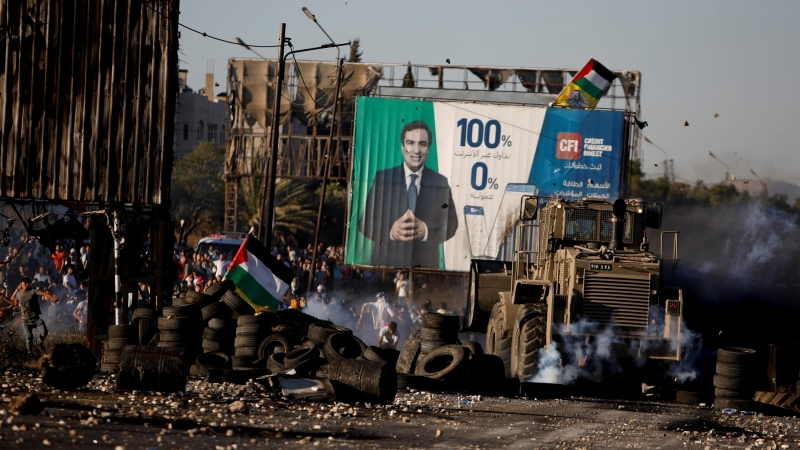 Imagen de archivo de varios manifestantes palestinos recibiendo ataques del Ejército de Israel, cerca del puesto de control de Hawara, en Nablús (Cisjordania). - REUTERS