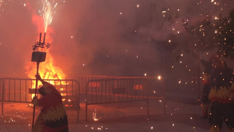 Els diables de Vila-rodona durant una actuació amb pirotècnia per la revetlla de Sant Joan, amb la foguera al mig de la plaça dels Arbres. Imatge del 23 de juny del 2020.