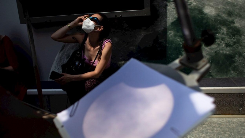Una mujer observa el eclipse en la República Checa.