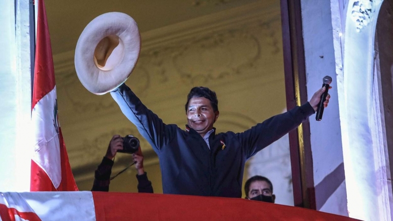 El candidato izquierdista a la presidencia de Perú Pedro Castillo saluda a seguidores desde un balcón de la sede de su partido Perú Libre, en Lima (Perú).