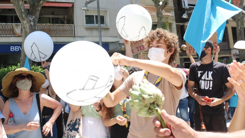 Un grup de participants en la manifestació contra l'ARE Sud i l'ampliació de l'aeroport al Prat de Llobregat petant uns globus, el 12 de juny de 2021