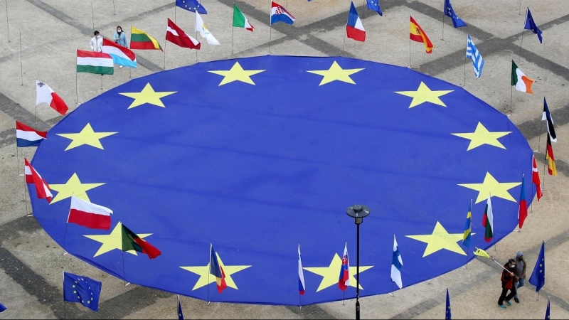 Una enorme bandera de la Unión Europea, rodeada junto a otras de los diferentes países comunitarios, aparece desplegada en la Plaza Schuman, frente a la sede de la Comisión Europea, en Bruselas, con motivo del Día de Europa. REUTERS/Yves Herman