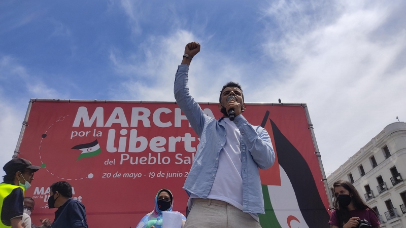 Un joven habla con un micrófono a la gente concentrada en la marcha, en la Puerta del Sol. - Guillermo Martínez