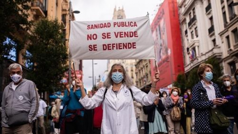 Una mujer con un cartel en la que se lee: 'Sanidad pública no se vende, se defiende', participa en la manifestación convocada por Marea Blanca, en defensa de la Atención Primaria de la Comunidad de Madrid, a 20 de junio de 2021.