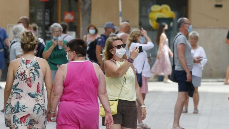 Varias personas andando por una calle.