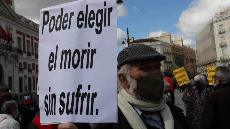 Un hombre con un cartel en el que se lee: `Poder elegir el morir sin sufrir´ durante una concentración de Derecho a Morir Dignamente en la Puerta del Sol, en Madrid.