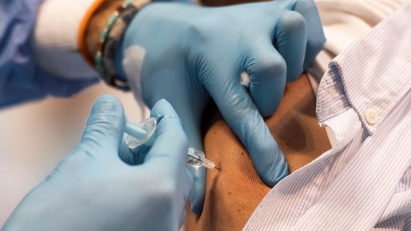 Imagen de archivo de un sanitario poniendo una vacuna contra el coronavirus.