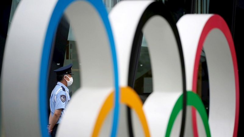 Un guardia de seguridad detrás del monumento de los anillos olímpicos en las inmediaciones del estadio olímpico de Tokio.