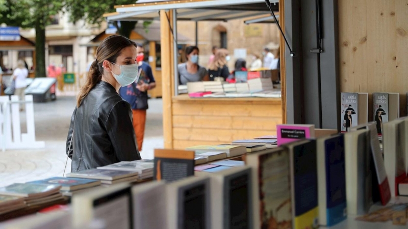 Una mujer con mascarilla en la feria del libro de Oviedo.