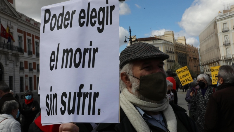 Un hombre con un cartel en el que se lee: `Poder elegir el morir sin sufrir´ durante una concentración de Derecho a Morir Dignamente en la Puerta del Sol, en Madrid (España), a 18 de marzo de 2021.