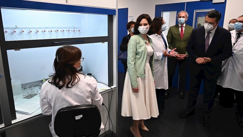 La presidenta de la Comunidad de Madrid, Isabel Díaz Ayuso, y el presidente del Comité Europeo de las Regiones, Apostolos Tzitzikostas, conversan con una de las trabajadoras mientras visitan el Hospital Enfermera Isabel Zendal.