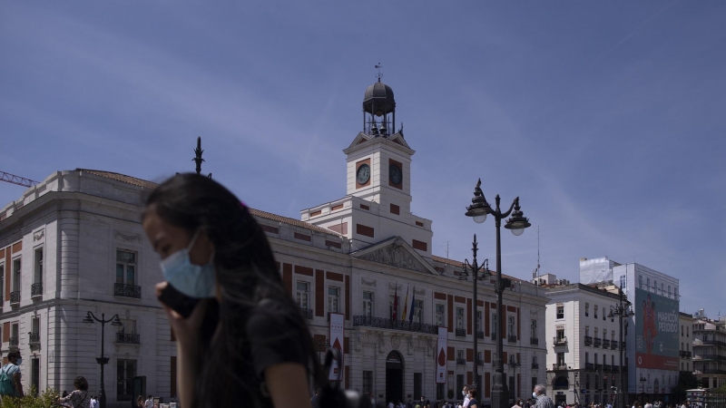 Una mujer con mascarilla en la Puerta del Sol, durante el último día en el que es obligatorio el uso de la mascarilla en exteriores.