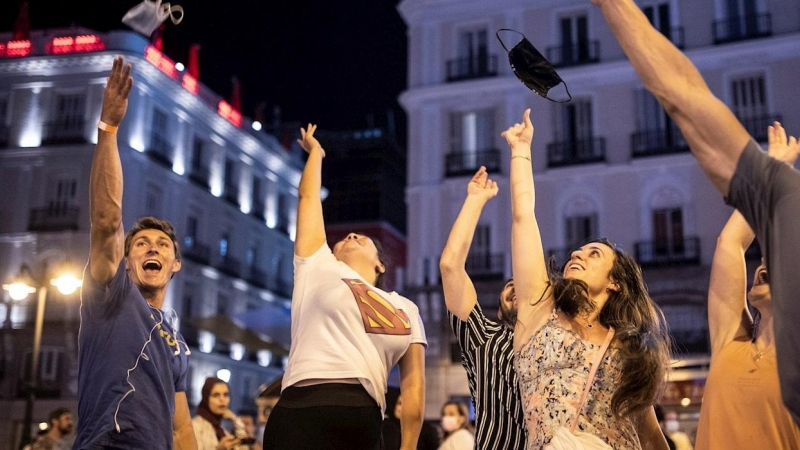 Varias personas celebran el fin del uso obligatorio de la mascarilla en espacios abiertos en la Puerta del Sol, en Madrid. - EFE