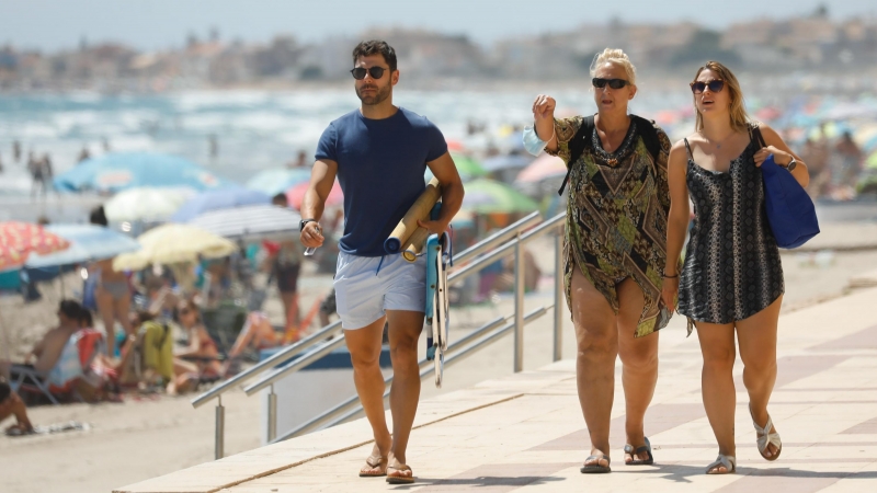 Tres personas caminan sin mascarilla, en el paseo marítimo de la playa de La Manga del Mar Menor. - EUROPA PRESS