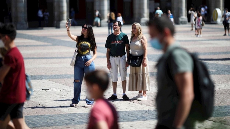 Varias personas pasean con y sin mascarilla, en la Plaza Mayor de Madrid. - EFE