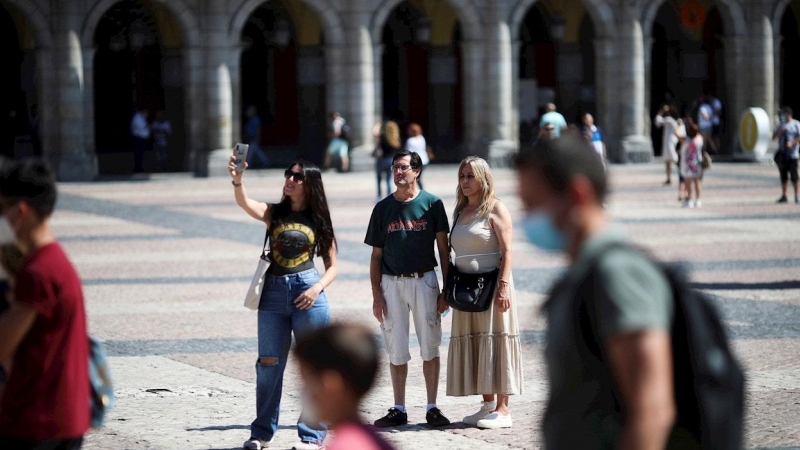 Varias personas pasean con y sin mascarilla, en la Plaza Mayor de Madrid. - EFE