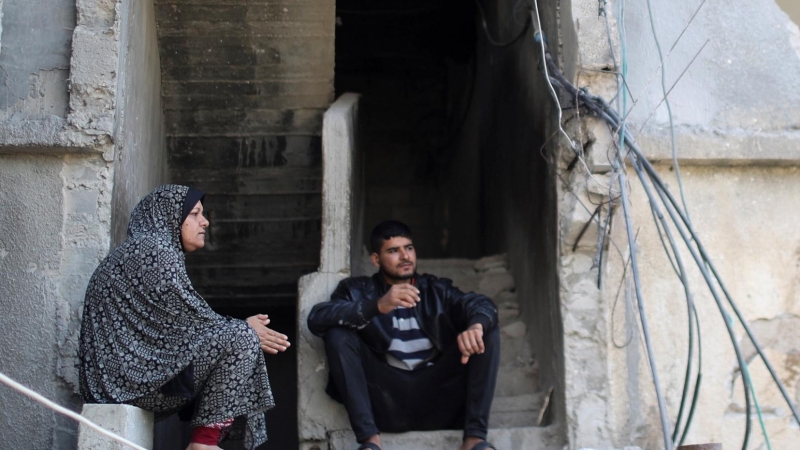 Palestinos se sientan sobre los escombros de su casa que fue destruida en los ataques aéreos israelíes durante los combates israelí-palestinos, en Gaza, el 9 de junio de 2021.
