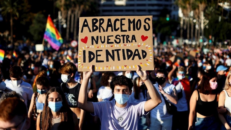 Un joven lleva una pancarta con el lema 'Abracemos nuestra identidad' durante la manifestación del Orgull LGTB+.