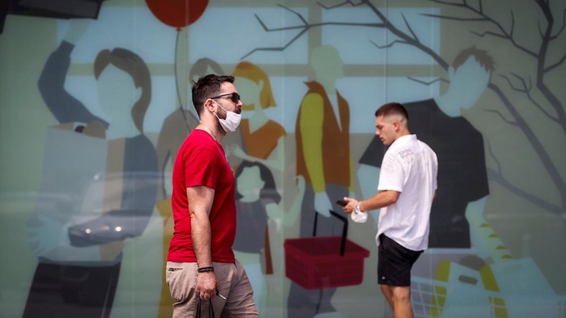 Dos hombres caminan con la mascarilla quitada este sábado en San Sebastián.