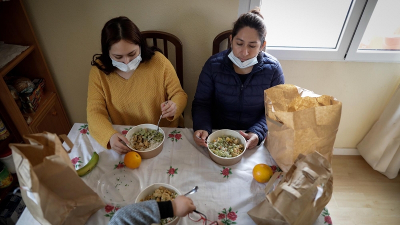 Dos mujeres y un niño durante la comida en su casa del barrio madrileño de Carabanchel prueban el menú de la ONG del chef José Andrés.