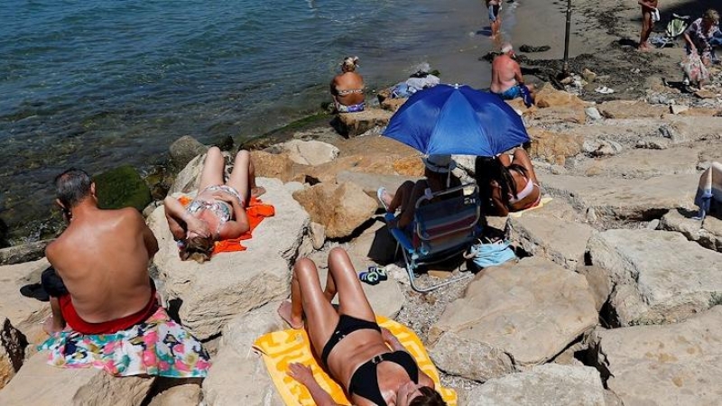 Turistas acuden a las playas de Benidorm en el primer fin de semana tras el final de los aparcelamientos en la arena para mantener la distancia social por los protocolos del covid.